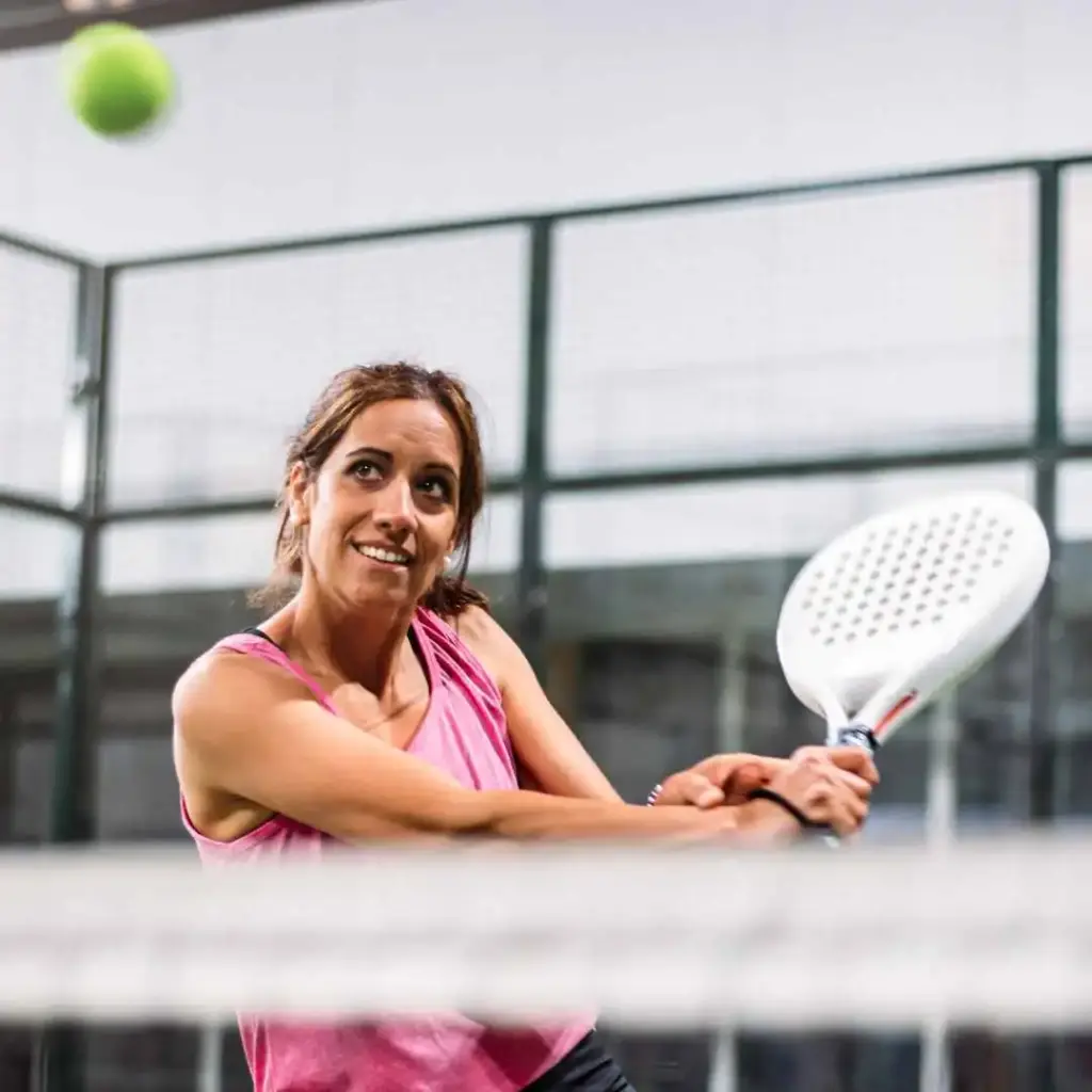 kvinde i lyserød trøje spiller padel